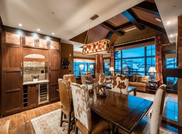 This luxurious mountain home boasts a stunning open-concept living area with floor-to-ceiling windows offering breathtaking views.