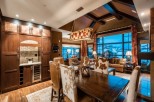This luxurious mountain home boasts a stunning open-concept living area with floor-to-ceiling windows offering breathtaking views.