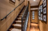 This stunning home boasts a grand staircase with wrought iron railings and plush carpeting, adding elegance to the interior.