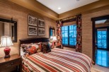 Luxurious mountain getaway boasting a king-size bed with designer bedding and stunning views.