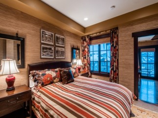 Luxurious mountain getaway boasting a king-size bed with designer bedding and stunning views.