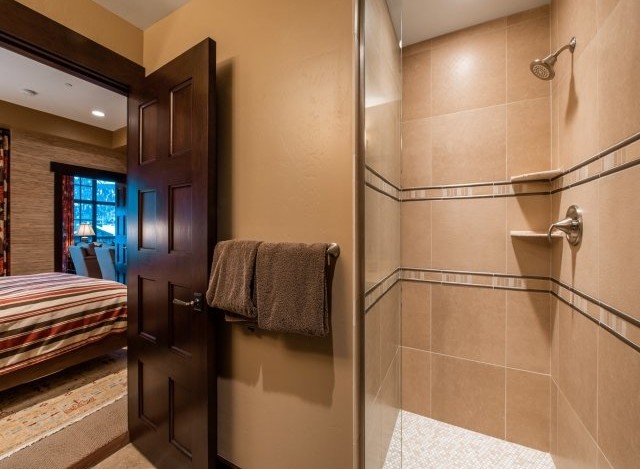 This luxurious bathroom boasts a spacious shower with elegant tile work and modern fixtures.