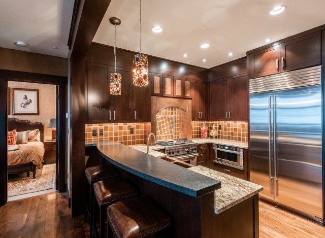 This luxurious kitchen boasts stunning dark wood cabinetry, granite countertops, and high-end stainless steel appliances.