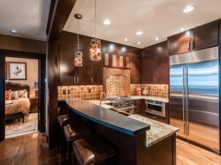 This luxurious kitchen boasts stunning dark wood cabinetry, granite countertops, and high-end stainless steel appliances.