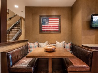 Cozy built-in banquette with leather seating and a rustic wooden table, perfect for intimate gatherings.
