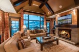 Luxurious mountain lodge with vaulted ceilings and expansive windows offering breathtaking views.