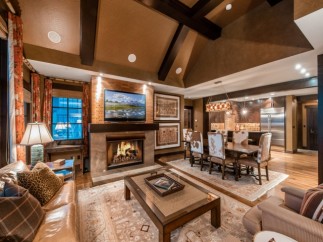 Luxurious mountain condo with a spacious open floor plan, featuring a cozy fireplace, elegant dining area, and stunning views.