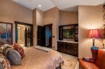 Luxurious master bedroom with a king-size bed, ensuite bathroom, and a built-in entertainment center.
