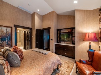 Luxurious master bedroom with a king-size bed, ensuite bathroom, and a built-in entertainment center.