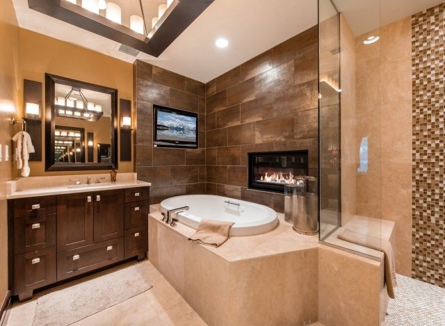 Luxurious bathroom with a built-in fireplace and a large soaking tub.