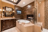 Luxurious bathroom with a built-in fireplace and a large soaking tub.