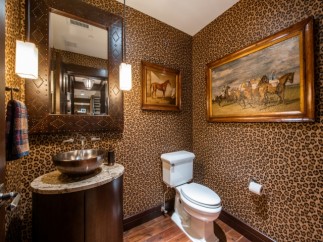This luxurious powder room boasts a stunning leopard-print wallpaper, creating a bold and chic atmosphere.