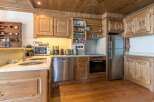 This stunning kitchen boasts a rustic charm with its wooden cabinetry and flooring, creating a warm and inviting atmosphere.