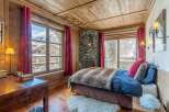 Experience the charm of this cozy bedroom, featuring a rustic stone fireplace and wooden accents throughout.