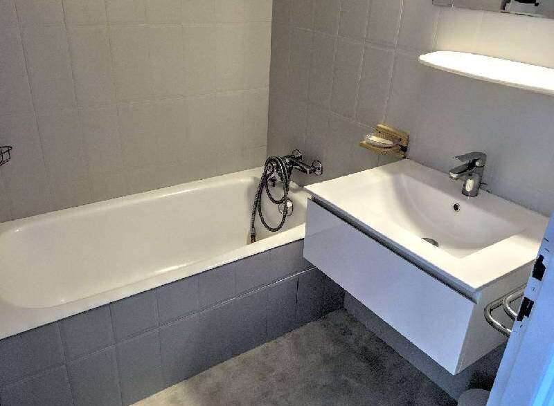 This modern bathroom features a sleek design with a bathtub and a stylish sink.