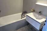 This modern bathroom features a sleek design with a bathtub and a stylish sink.