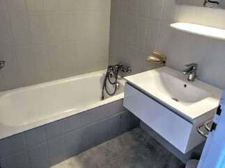 This modern bathroom features a sleek design with a bathtub and a stylish sink.