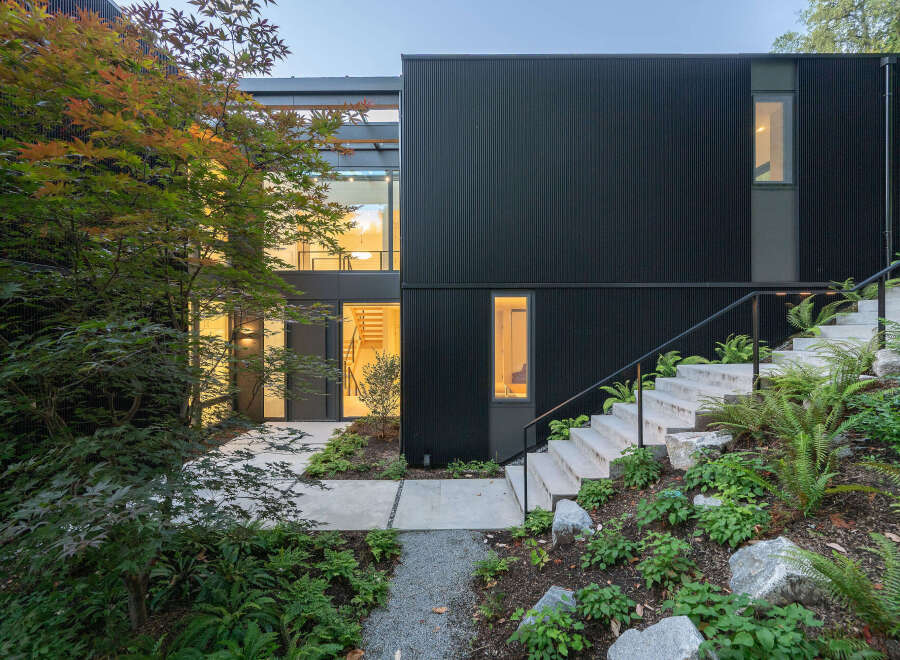 This modern home boasts a striking black exterior with a contemporary design.