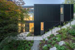 This modern home boasts a striking black exterior with a contemporary design.