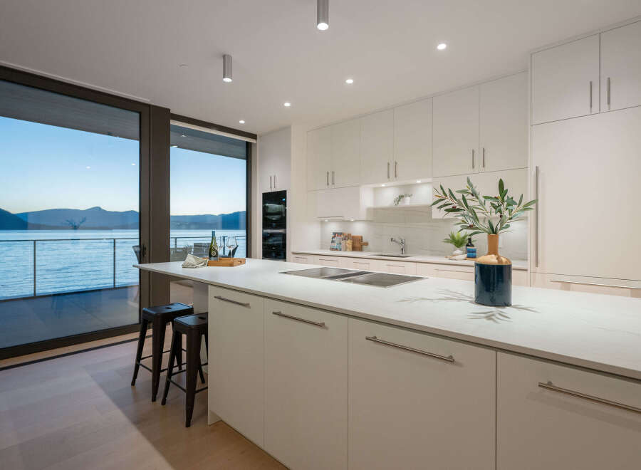 This stunning kitchen boasts a modern design with sleek white cabinetry and a spacious island, perfect for culinary creations and entertaining.
