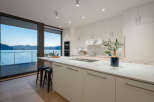 This stunning kitchen boasts a modern design with sleek white cabinetry and a spacious island, perfect for culinary creations and entertaining.