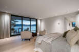 Experience luxury living with this stunning bedroom featuring breathtaking water views.
