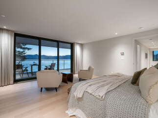 Experience luxury living with this stunning bedroom featuring breathtaking water views.