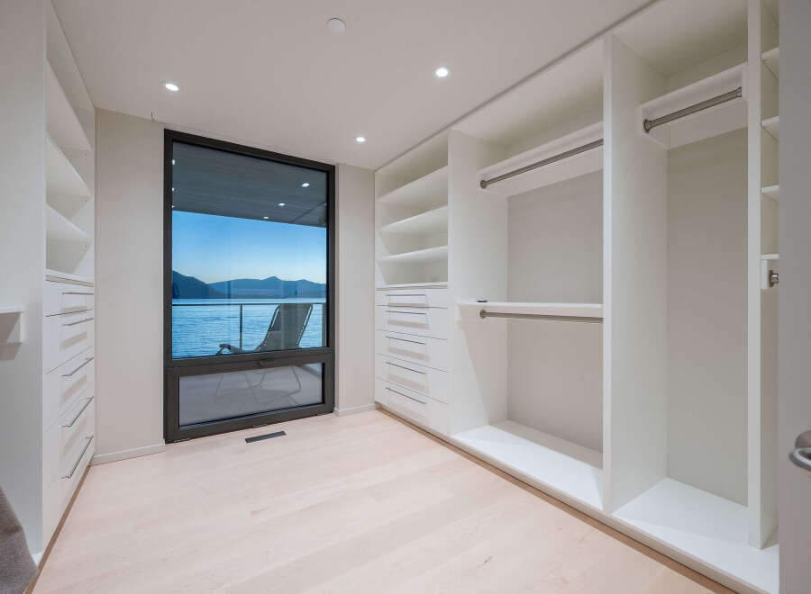 Step into luxury with this stunning walk-in closet, boasting ample storage and a sleek, modern design.