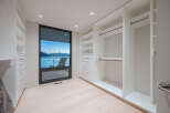 Step into luxury with this stunning walk-in closet, boasting ample storage and a sleek, modern design.