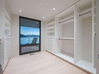Step into luxury with this stunning walk-in closet, boasting ample storage and a sleek, modern design.