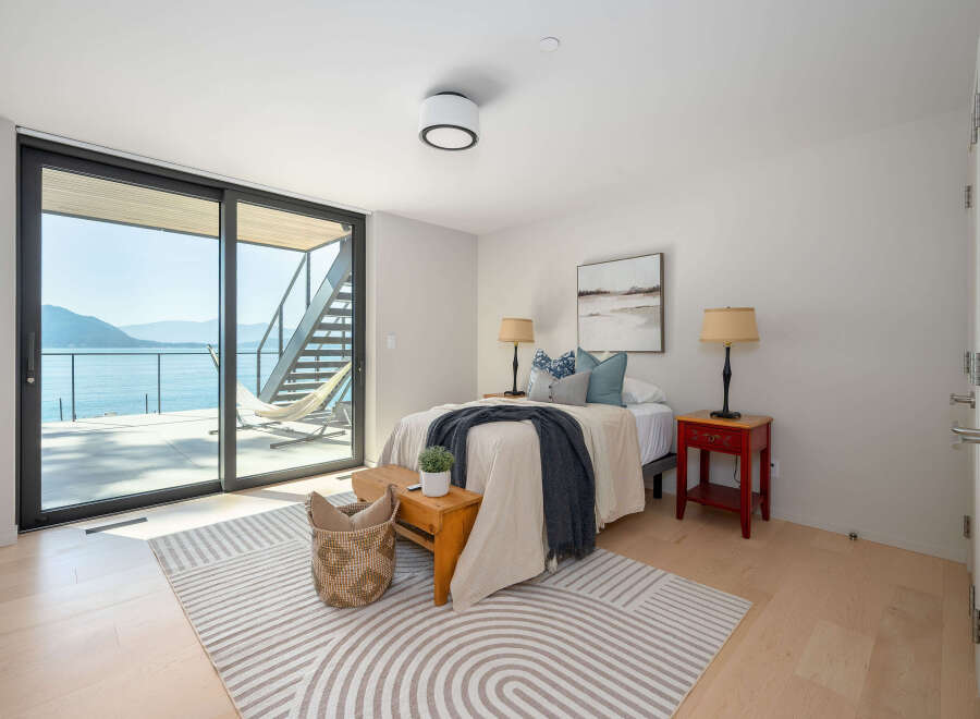 Experience luxury living with this stunning bedroom featuring breathtaking water views.