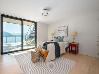Experience luxury living with this stunning bedroom featuring breathtaking water views.