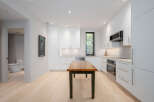 This modern kitchen boasts sleek white cabinetry, offering ample storage and a clean aesthetic.