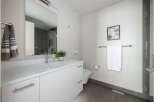 This modern bathroom boasts a sleek, minimalist design with a pristine white vanity and a large mirror.