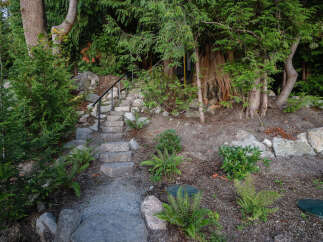 Discover the charm of this property with its inviting stone staircase leading to a hidden oasis.