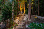 Discover a serene retreat with this stunning property featuring a stone staircase that leads you through a lush, wooded landscape.
