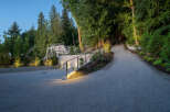 Discover the allure of this stunning property, featuring a beautifully illuminated gravel driveway that leads to a private oasis.