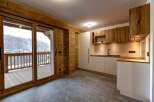 This stunning property features a modern kitchen with sleek white cabinetry and warm wooden accents.