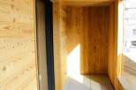 Step into this inviting balcony, showcasing a warm embrace of natural wood paneling.