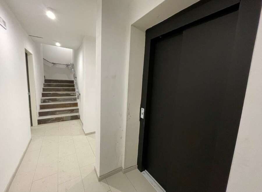 Discover this inviting property featuring a modern elevator and a well-lit staircase.