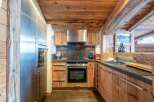 This stunning kitchen boasts a rustic charm with its wooden cabinets and ceiling, creating a warm and inviting atmosphere.