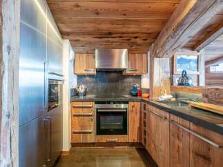 This stunning kitchen boasts a rustic charm with its wooden cabinets and ceiling, creating a warm and inviting atmosphere.