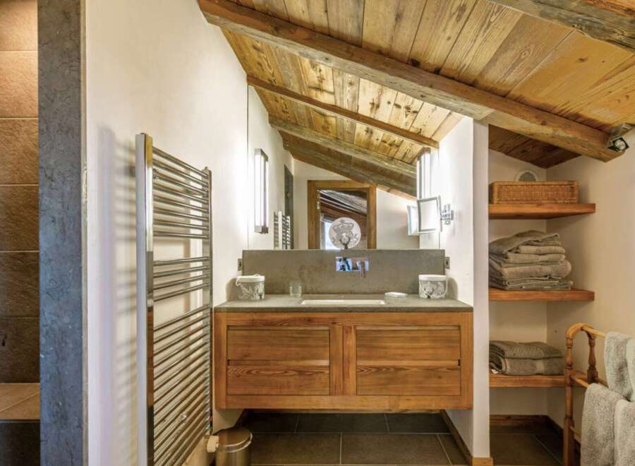 This stunning bathroom showcases rustic charm with its wooden ceiling and cabinetry.