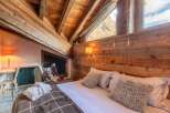 Experience the rustic charm of this stunning bedroom, featuring exposed wooden beams and a cozy ambiance.