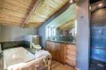Experience luxury in this stunning bathroom featuring a rustic wooden ceiling and elegant design.