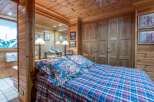 This cozy bedroom features a warm, inviting ambiance with its wooden walls and ceiling.