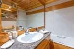 This cozy bathroom features a beautiful wooden ceiling and cabinetry, creating a warm and inviting atmosphere.