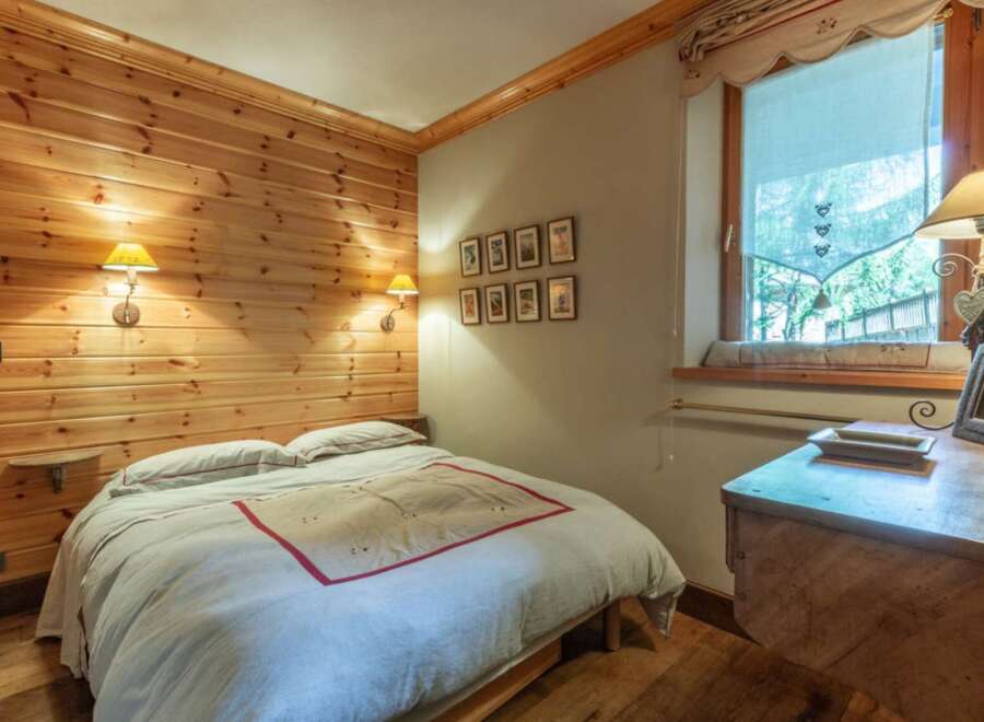 Cozy bedroom with wood paneling and a comfortable bed.