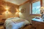 Cozy bedroom with wood paneling and a comfortable bed.
