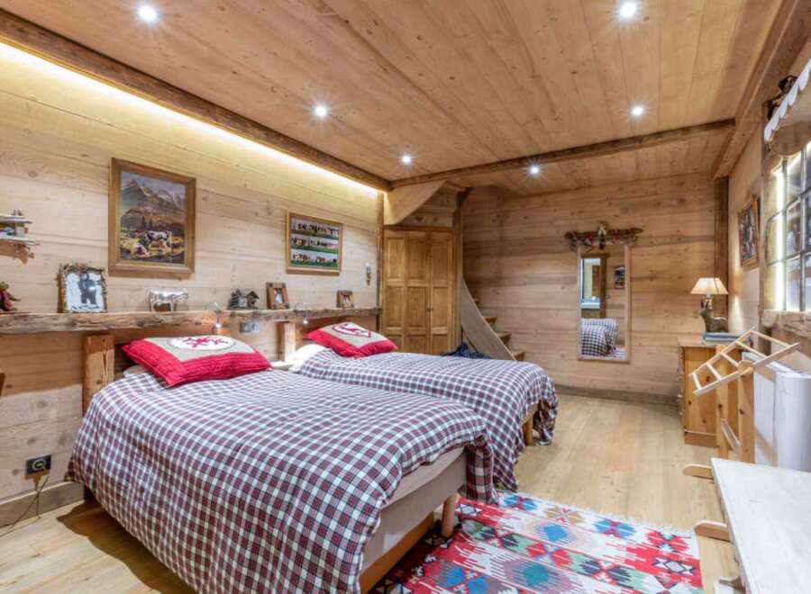 Experience rustic charm in this cozy bedroom, featuring warm wooden walls and ceilings.